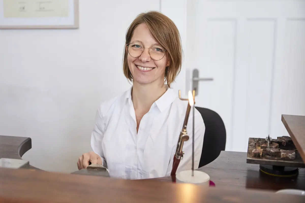 Feingoldschmiedin bei der Arbeit in der Goldschmiede, detaillierte Schmuckherstellung.